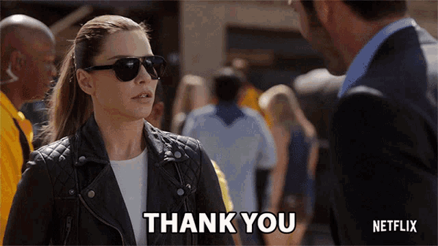 a woman wearing sunglasses says thank you to a man