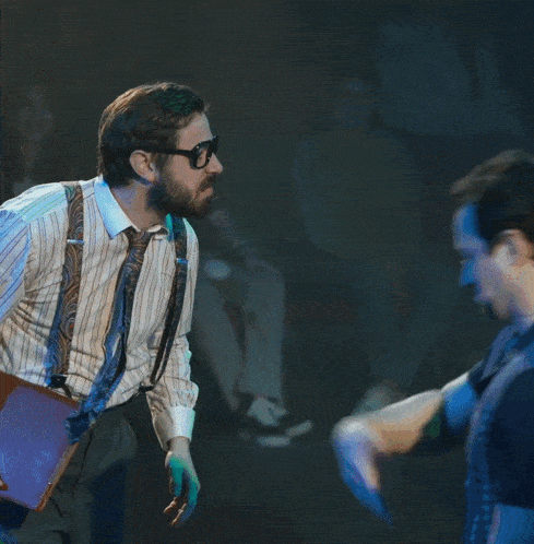 a man and a woman are standing next to each other and the man is wearing suspenders