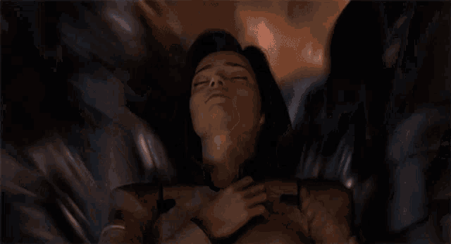a woman laying down with her eyes closed and her hands on her chest