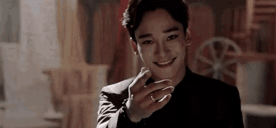 a man in a suit and tie is smiling and holding a ring in his hand .
