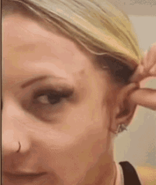 a close up of a woman 's ear with a nose ring .