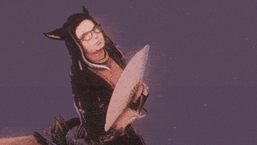 a man with cat ears is holding a fan in front of a body of water