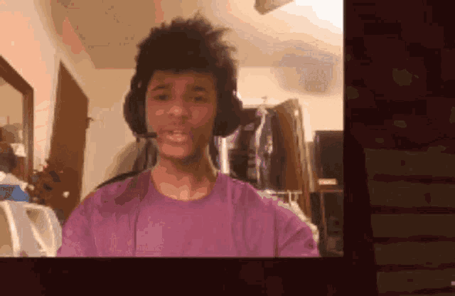 a man in a purple shirt is wearing headphones