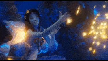a woman in a fairy costume is surrounded by fireworks