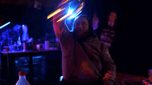 a blurry photo of a man holding a torch with a blue light behind