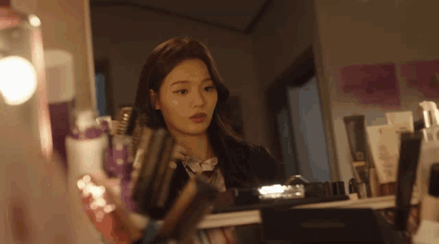 a woman looks at herself in a mirror while holding a brush
