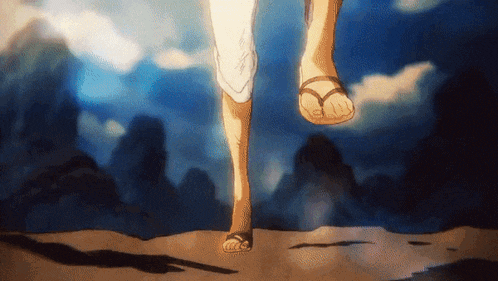a person wearing flip flops is walking on a sandy surface