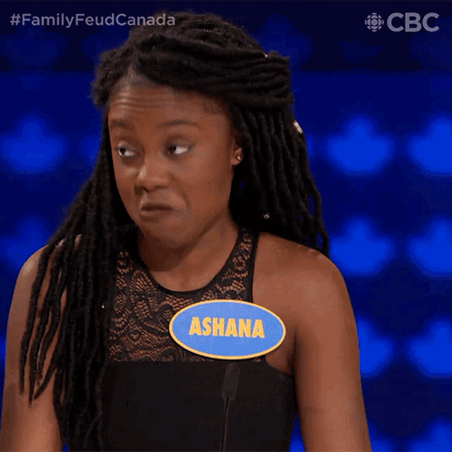 a woman with dreadlocks is wearing a name tag that says ashana