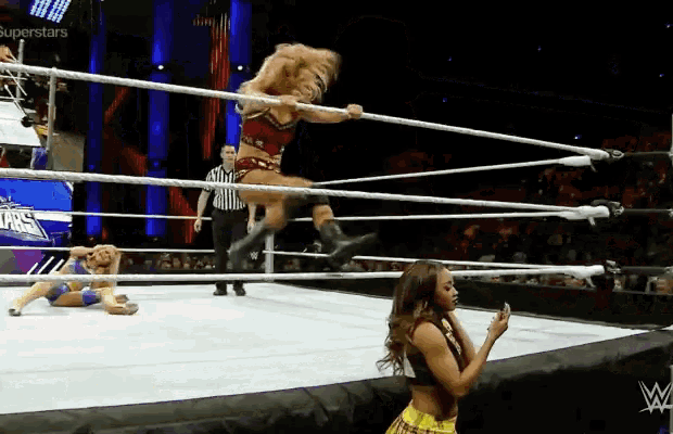 a woman in a wrestling ring with superstars written on the wall