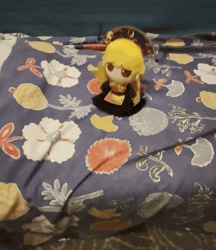 a stuffed animal is laying on a bed with a floral pattern