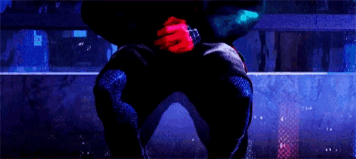 a person with red hands is sitting in the dark