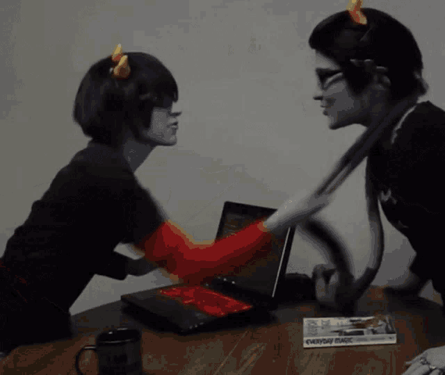 a couple of people standing next to a laptop and a magazine that says everyday mail on it