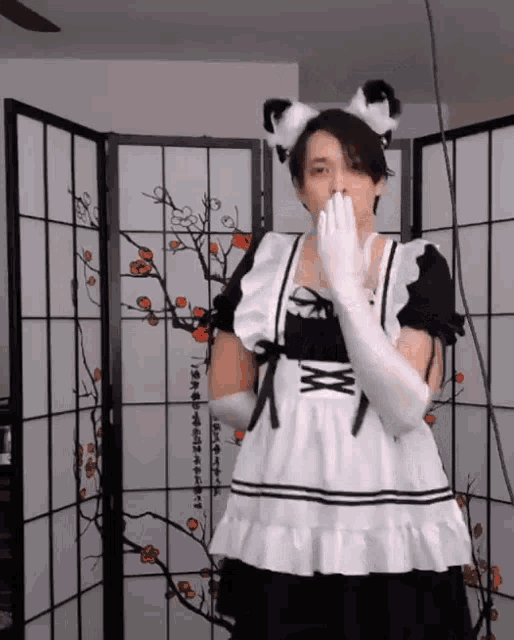 a man in a maid costume covering his mouth
