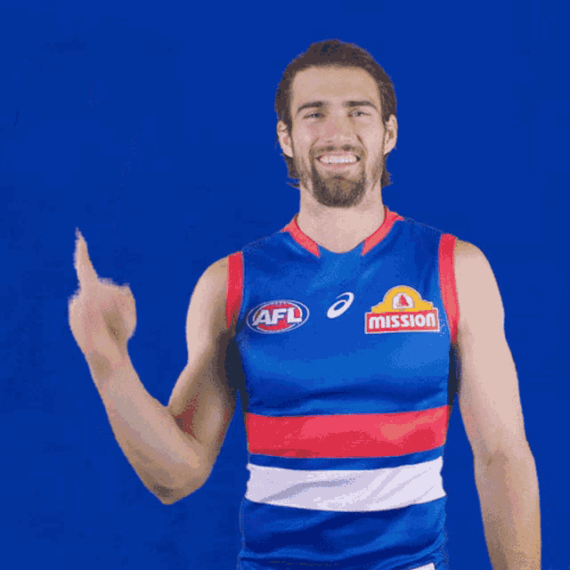 a man wearing a blue and red afl jersey giving a thumbs up