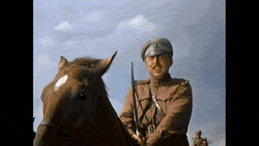 a man in a military uniform is riding a horse .