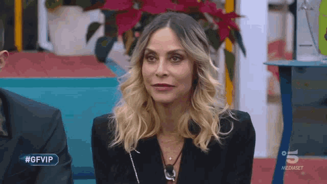 a woman is sitting in front of a sign that says #gfvip on it