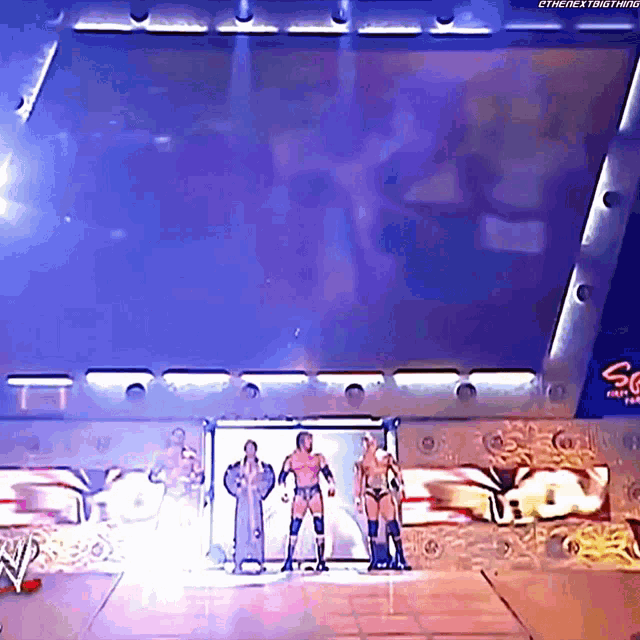 a group of wrestlers are standing on a stage in front of a sign that says ' sg ' on it