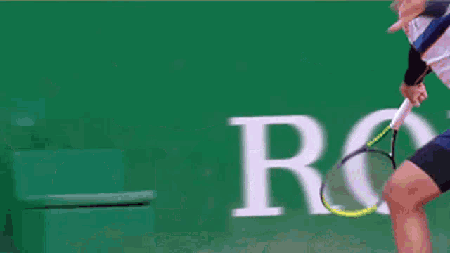 a man playing tennis in front of a rolex logo