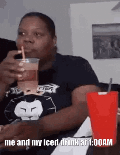 a woman is drinking an iced drink at 1:00 am .