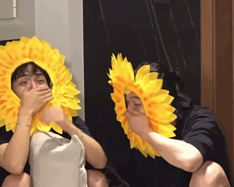 two people wearing yellow sunflowers on their heads