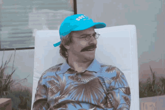 a man with a mustache wearing a blue hat and glasses