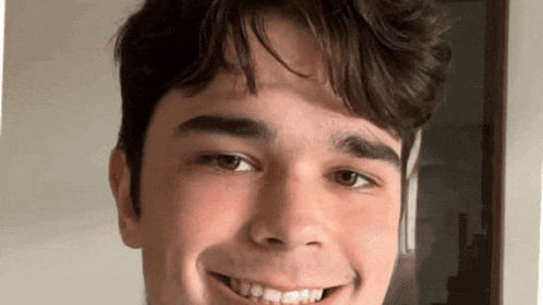 a young man with braces is smiling for the camera .