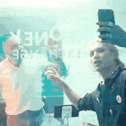 a man is taking a selfie in front of a mirror .