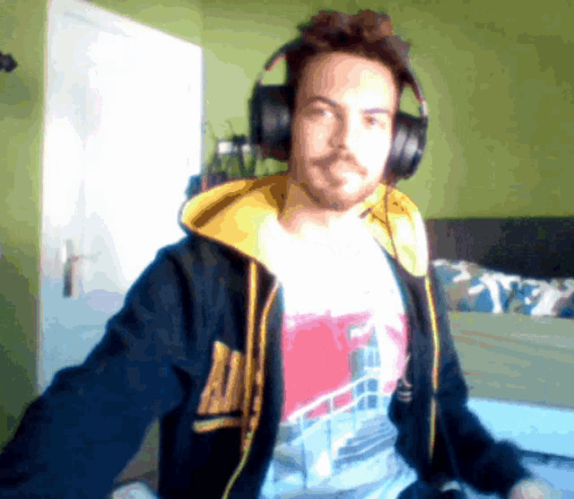 a man wearing headphones and a hoodie with the letter a on the front