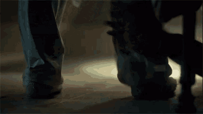 a close up of a person 's feet standing next to each other on a wooden floor .