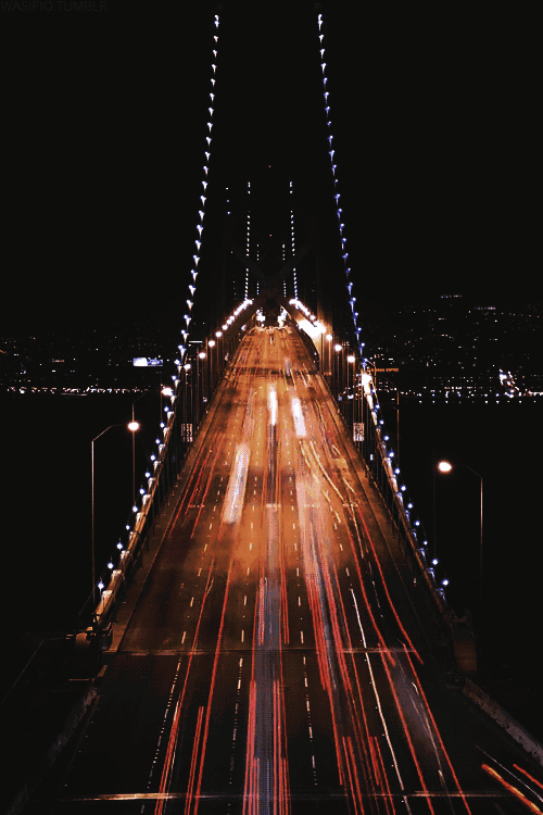 a bridge that is lit up at night and has a sign that says no trucks