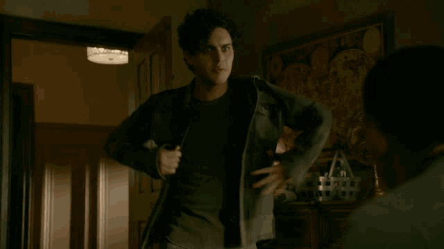 a man wearing a black shirt and a grey jacket