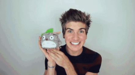 a young man is holding a stuffed animal in front of his face .