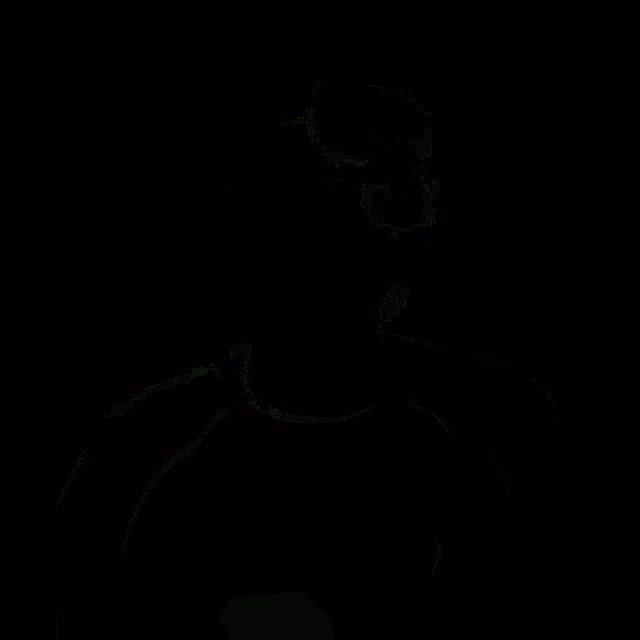 a man is laughing with his mouth open and his eyes closed while wearing a black jacket .