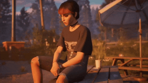 a woman is sitting on a picnic table with a cup of coffee in her hand .