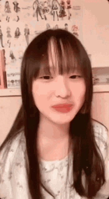 a young girl with long hair and bangs is making a face .