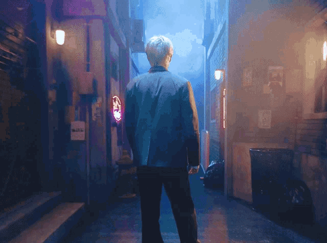 a man in a suit is standing in a dark alleyway with a neon sign that says ' a ' on it