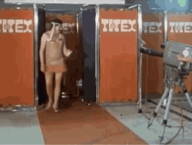 a woman is walking through a room with a sign that says ' rex ' on it