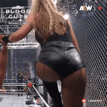 a woman in leather shorts is standing in front of a fence .