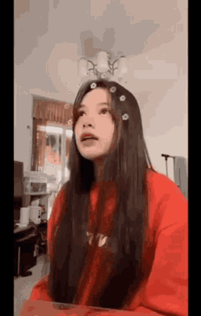 a woman with long hair is wearing a red sweater and a red shirt .