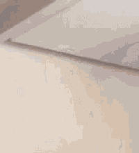 a blurry picture of a woman 's face against a white wall .