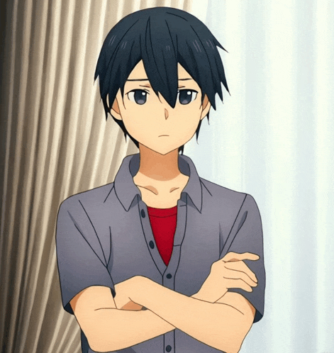 a young man with his arms crossed is standing in front of a window