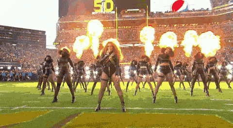 a group of cheerleaders are performing on a football field in front of a scoreboard with the number 50 on it