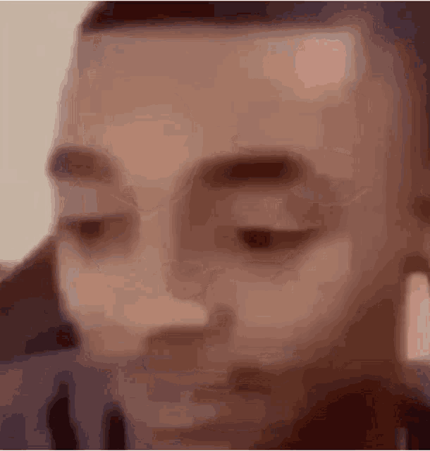 a close up of a person 's face with their eyes closed and a blurry background .