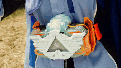 a person is wearing a blue and orange belt with a triangle on it