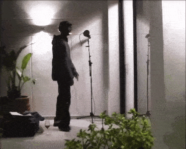 a man standing in front of a microphone in a room