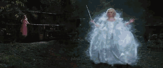 a little girl in a pink dress is standing next to a little girl in a white dress holding a wand