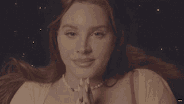 a woman wearing a pearl necklace sticks out her tongue