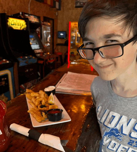 a young boy wearing glasses and a shirt that says lions