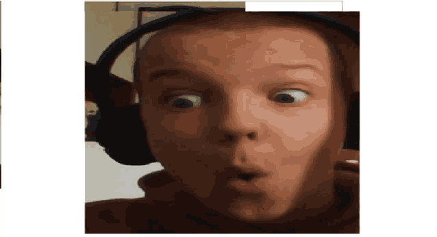 a young man wearing headphones making a surprised face