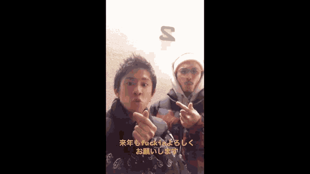 two men giving the middle finger in front of a sign that says s